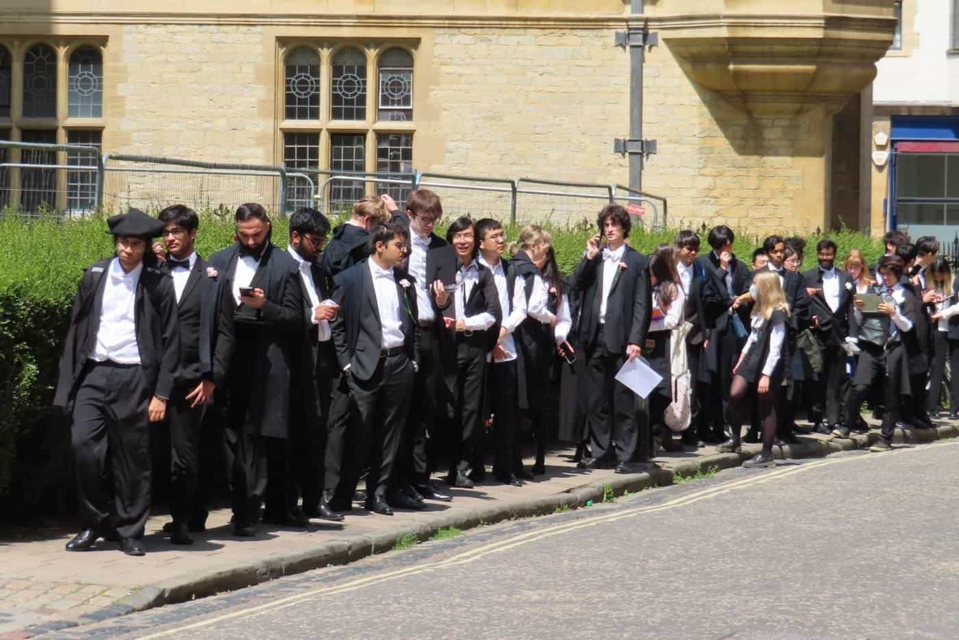 Students in formal dress lining up outside an exam venue